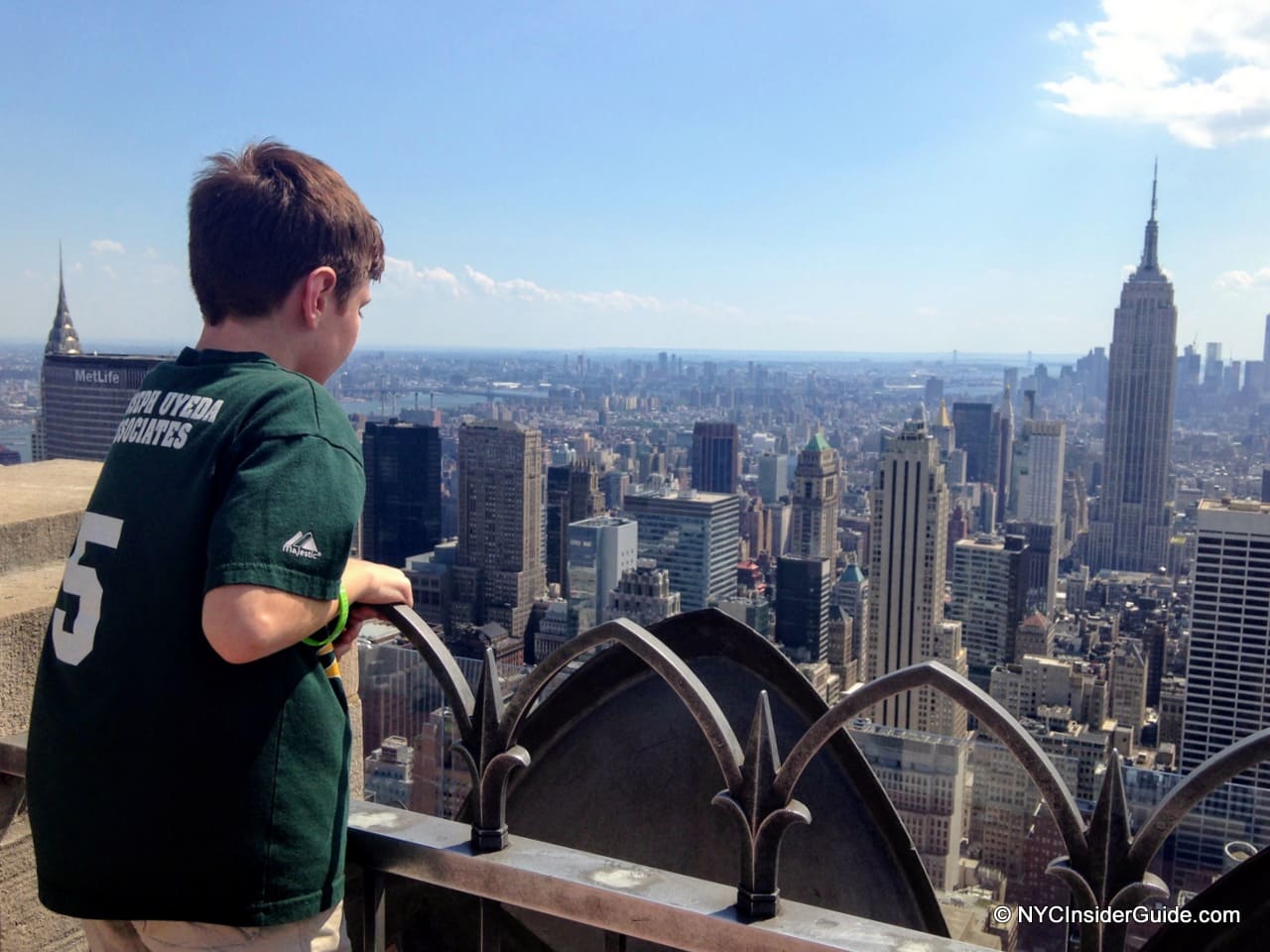 Boy looking out over NYC skyline from Top of the Rock